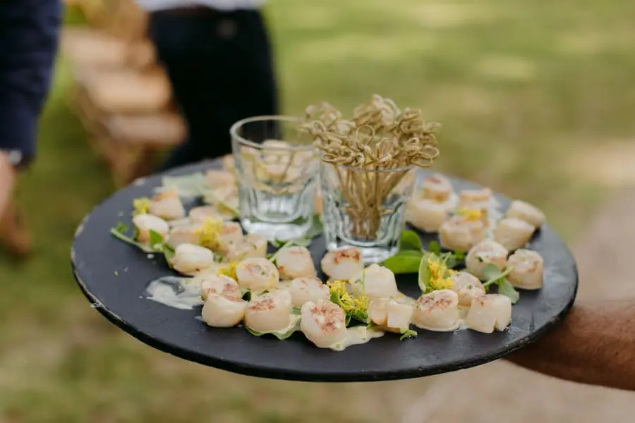 Small savoury appetisers arranged on a black serving tray