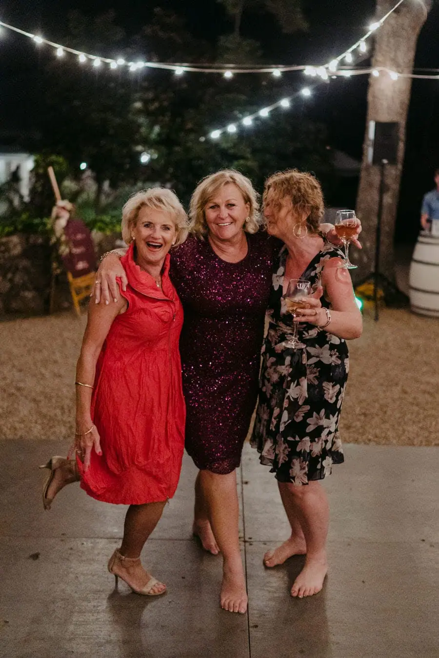 Three women smiling together on the outdoor dance floor