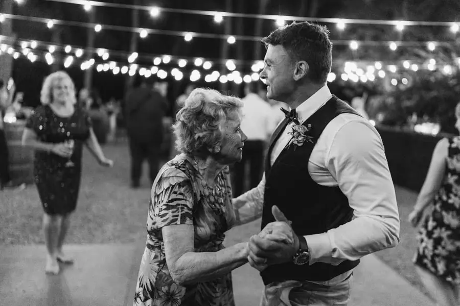 Black and white photograph of the groom dancing with a grey-haired woman