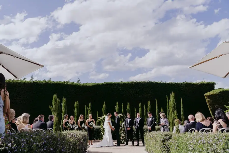 Wide view of the outdoor wedding ceremony beneath a cloudy sky