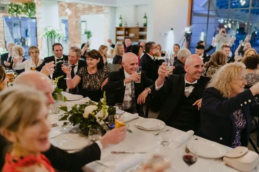 Guests raising drinks for a toast around the reception tables