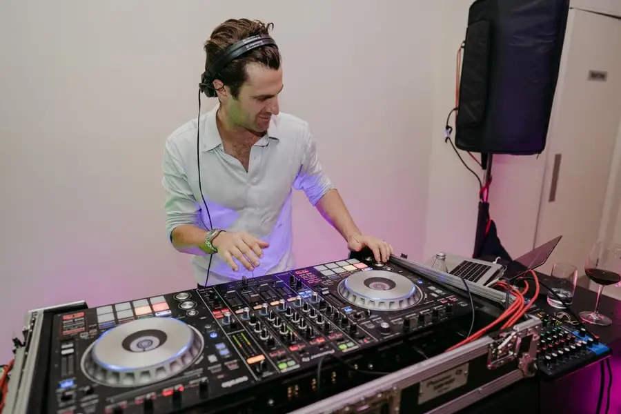 DJ wearing headphones and working at a mixing console.