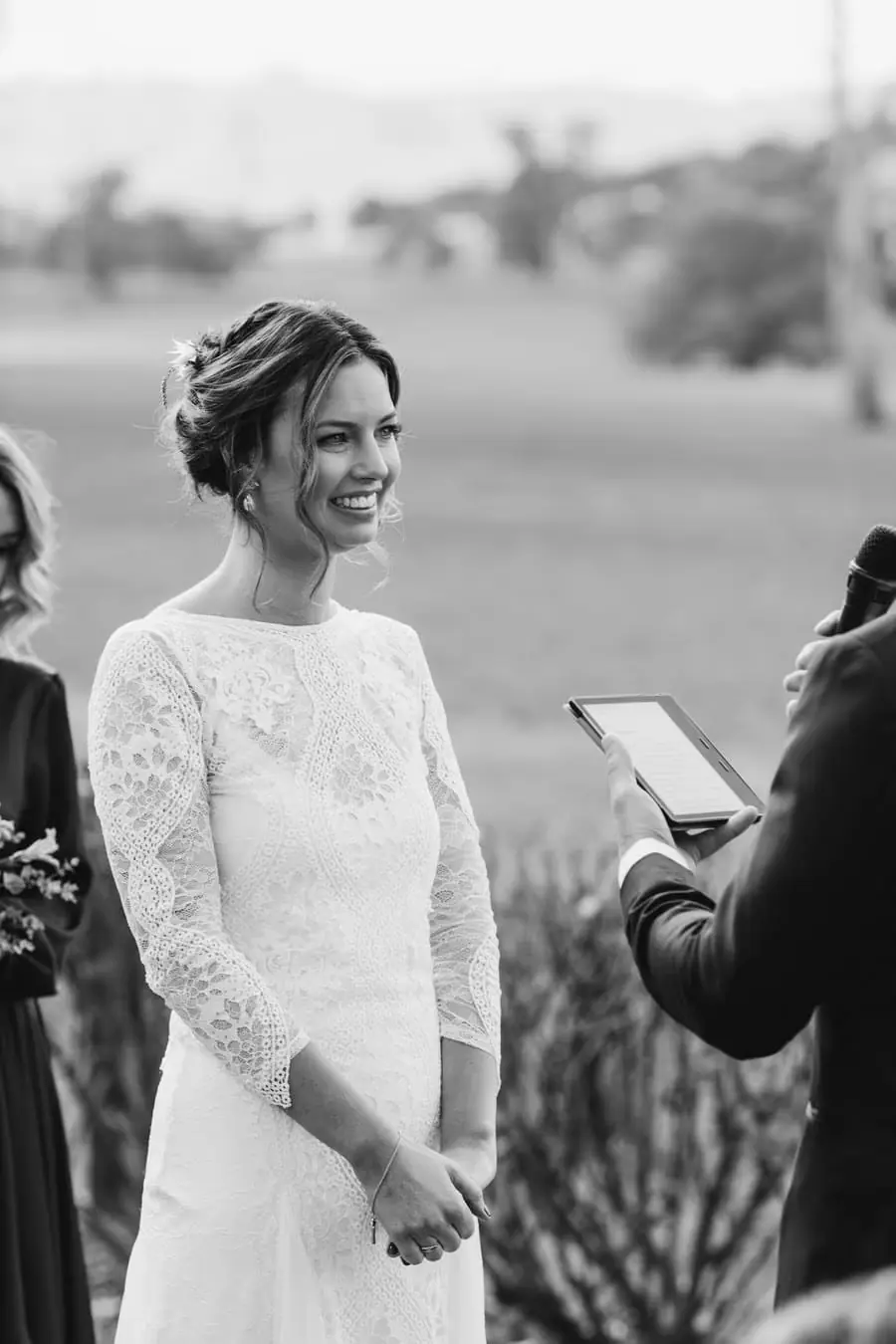 Black-and-white photograph of the smiling bride facing the celebrant