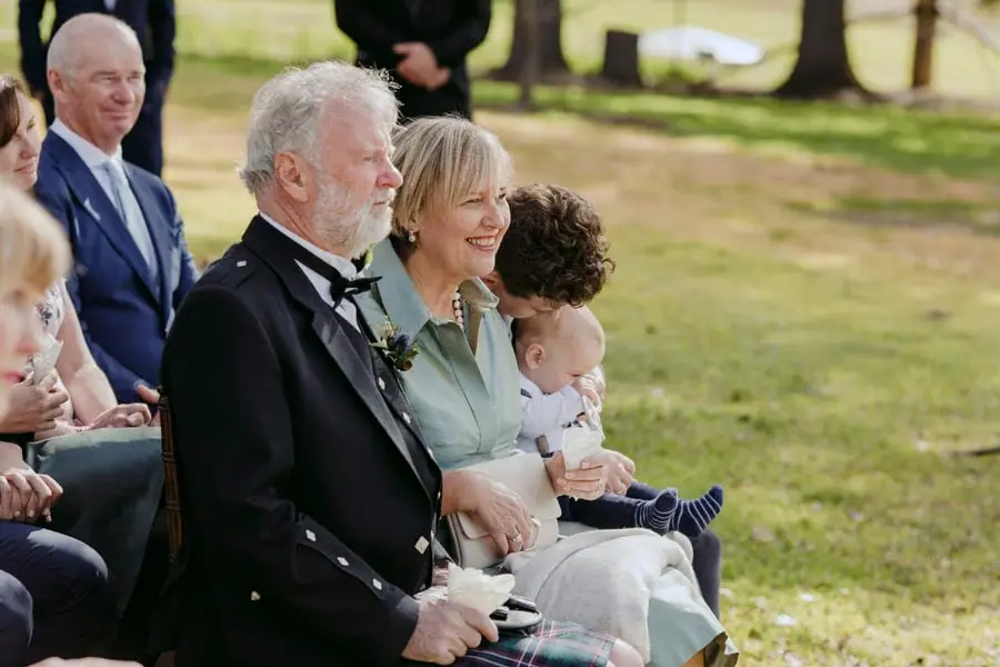 Older couple seated with a small child among wedding guests