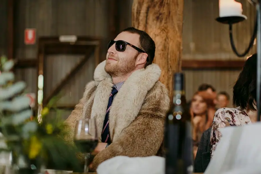 Guest wearing sunglasses and a fur stole seated at the reception