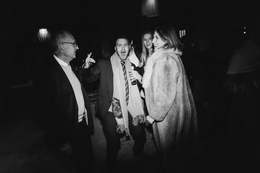 Black-and-white photograph of guests dancing, including a woman wearing a fur stole