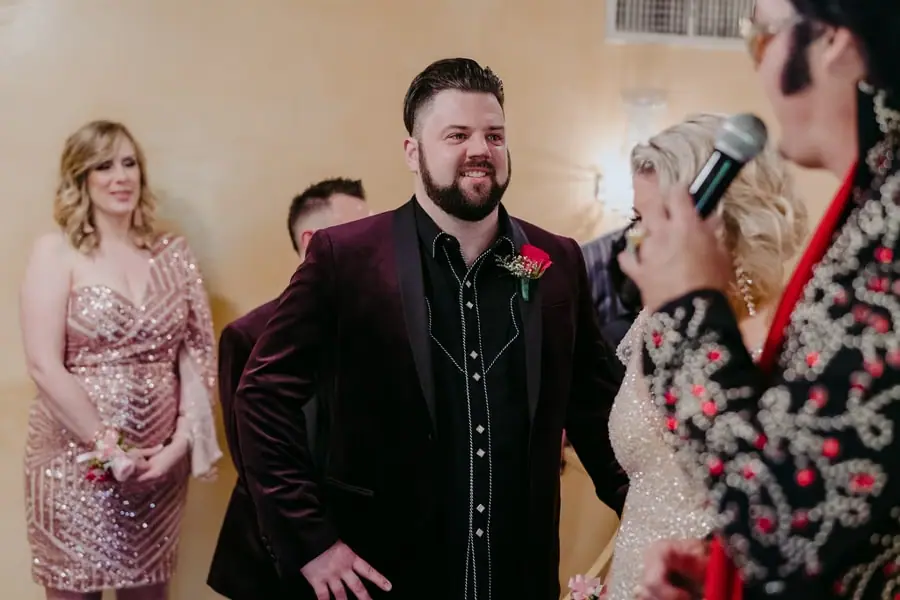 Groom smiling toward the Elvis impersonator during the ceremony