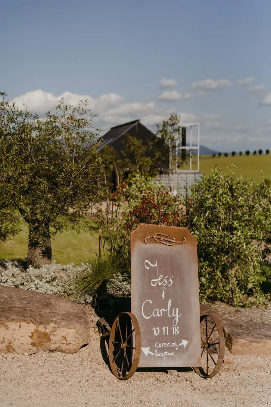 Decorative wedding sign standing among rocks and garden plants