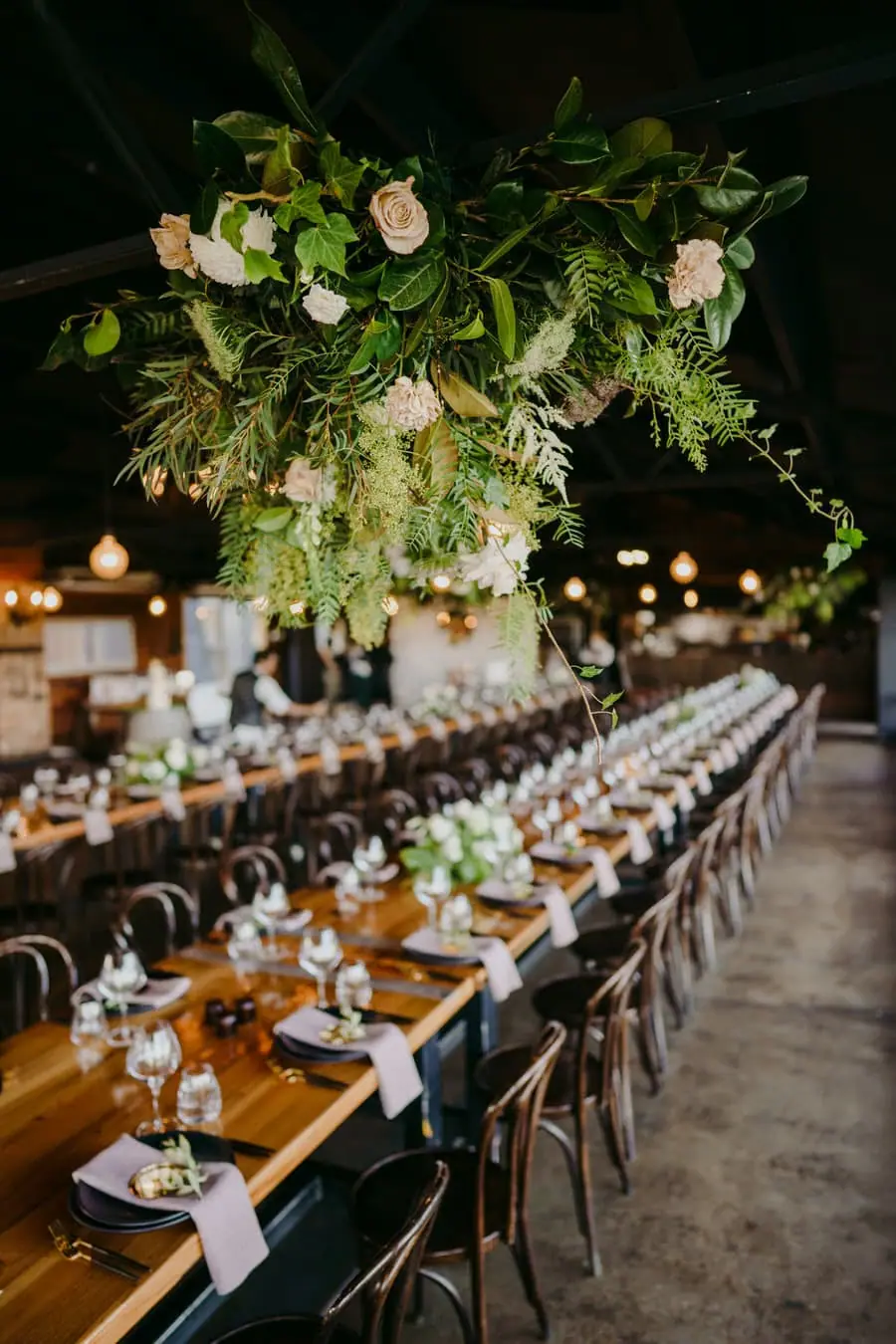 Suspended floral arrangement above a long reception table