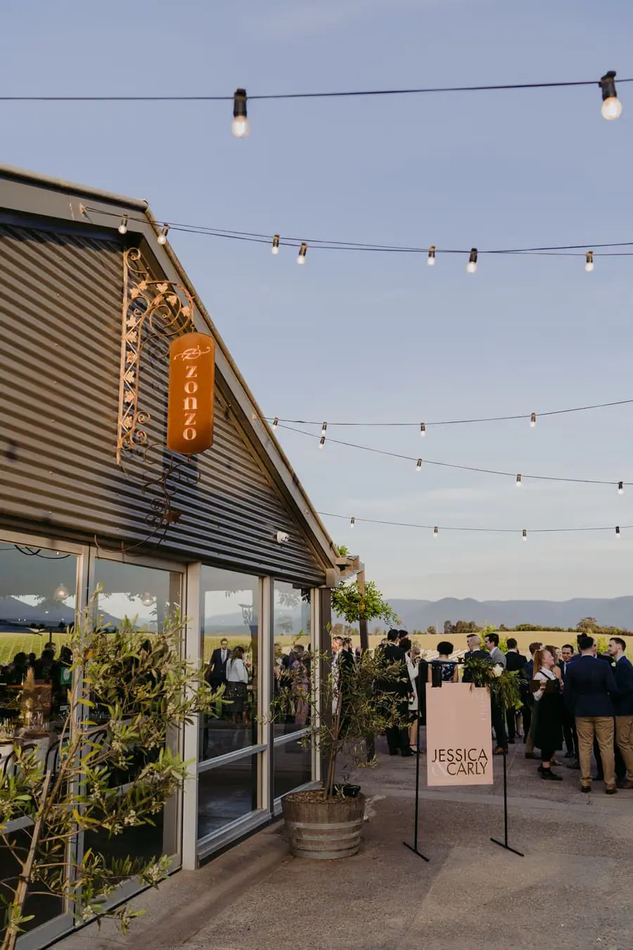 Reception building and outdoor path beneath strings of festoon lights