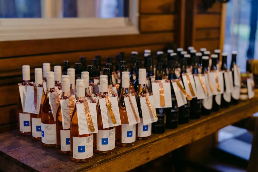Wine bottles with individually tagged labels arranged for wedding guests