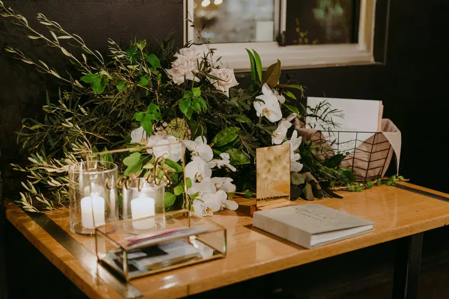 Wedding guest book and cards displayed beside flowers and candles