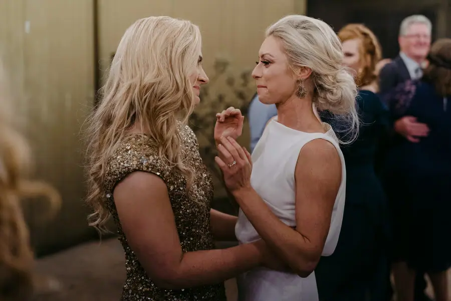 Two brides looking closely at one another while dancing outside