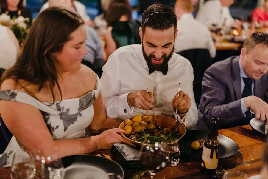 Seated guests sharing a platter of food during the reception