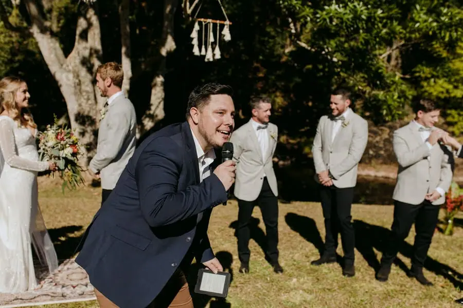 Celebrant leaning forward and smiling with a microphone