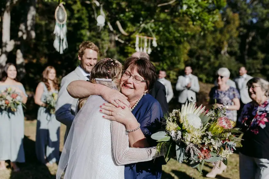 Bride embracing a smiling guest after the ceremony