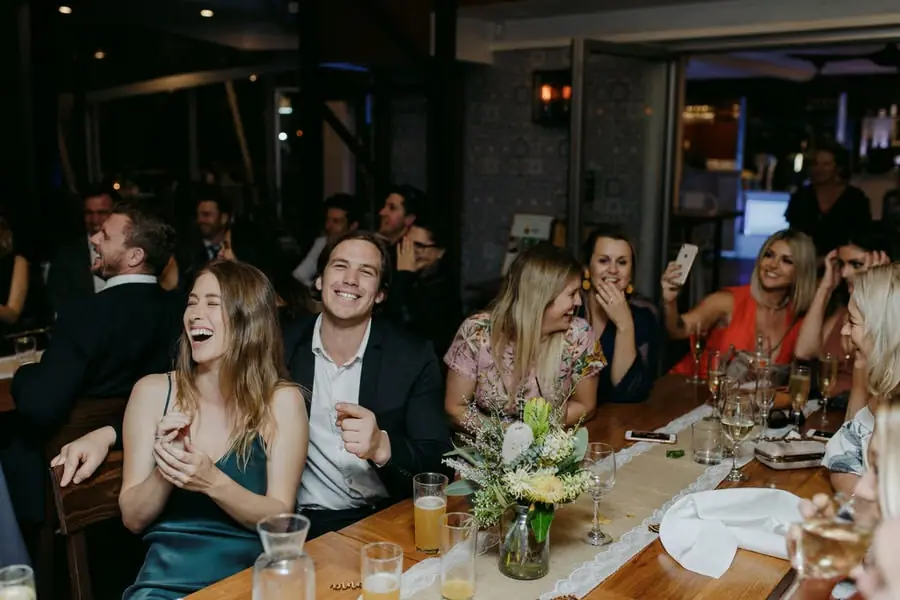 Guests laughing together around a reception table