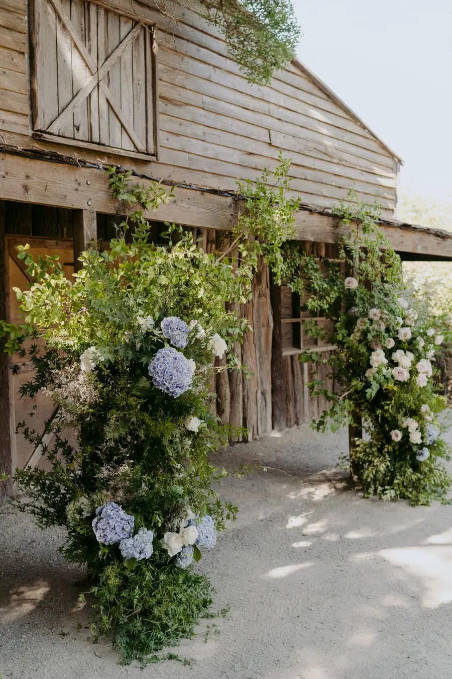 White and blue flowers decorating the entrance of a timber ceremony building