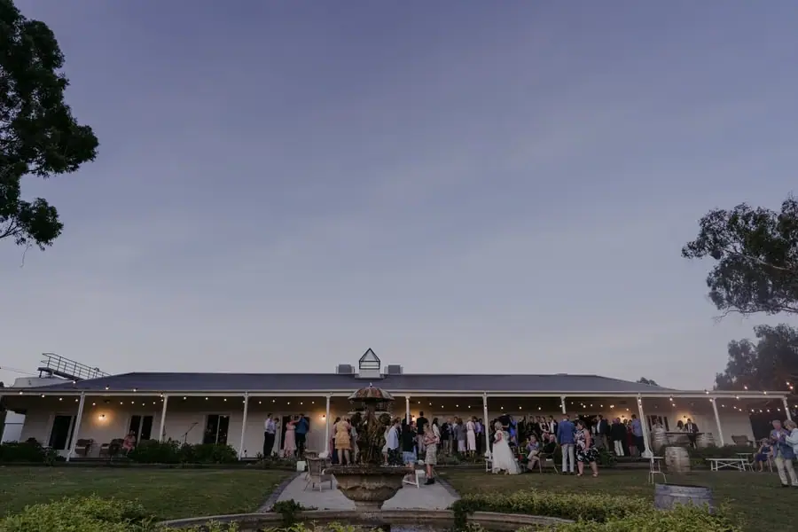 Guests gathering outside the illuminated reception building at dusk