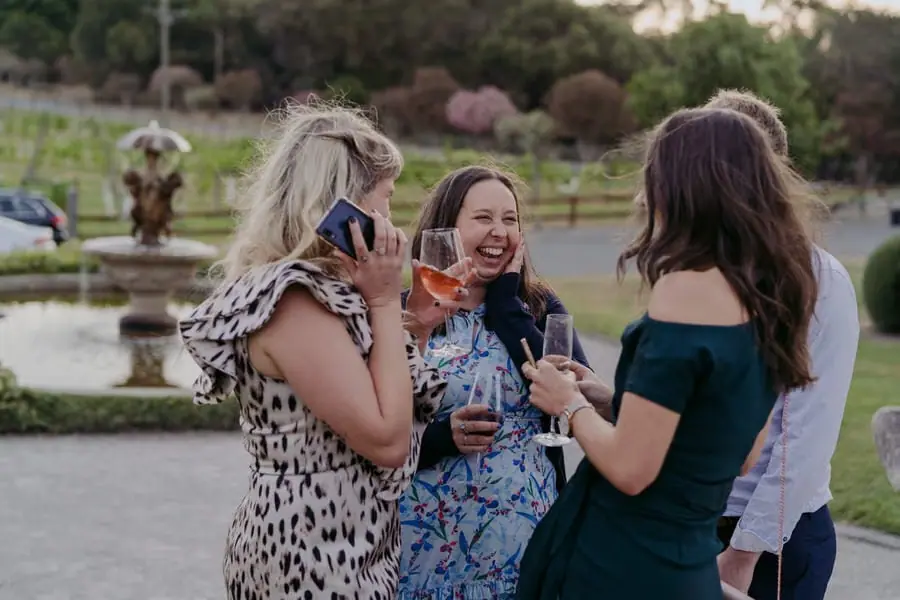 Women smiling and chatting with drinks in the garden
