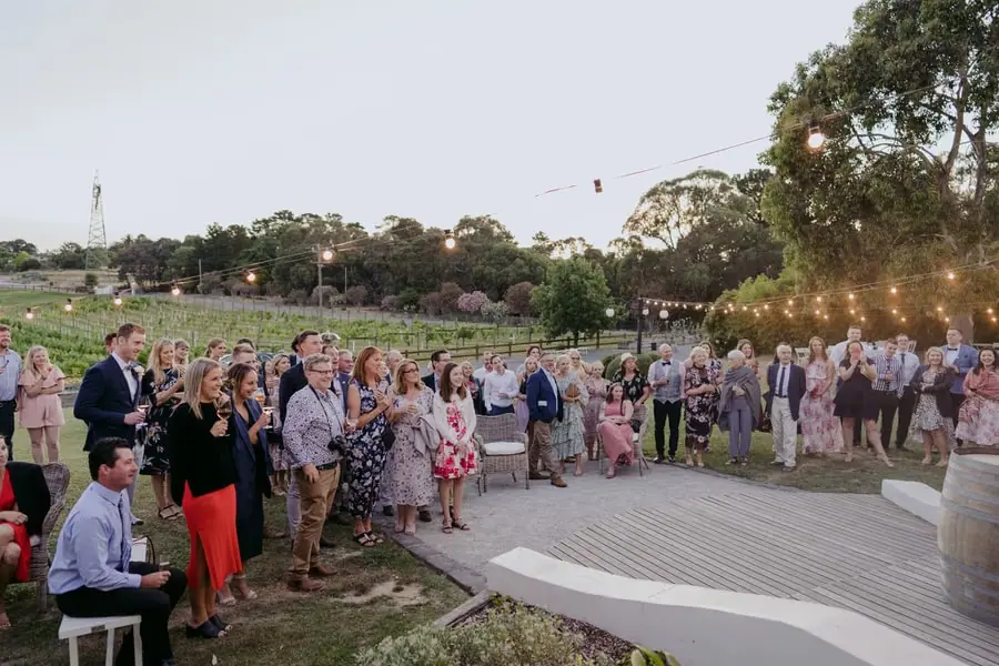 Guests gathering around the outdoor reception area in evening light