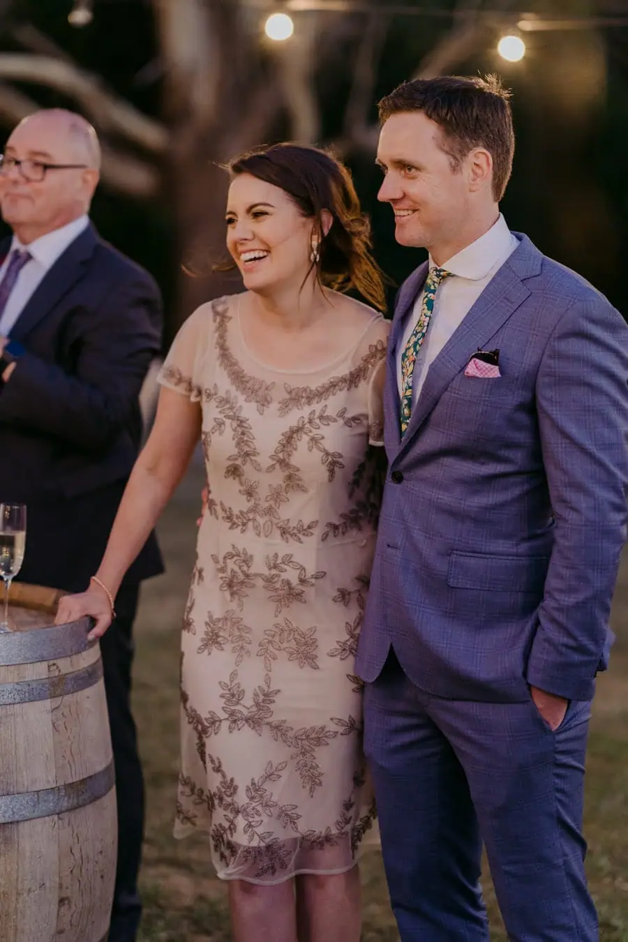 Two guests smiling together while listening to a reception speech