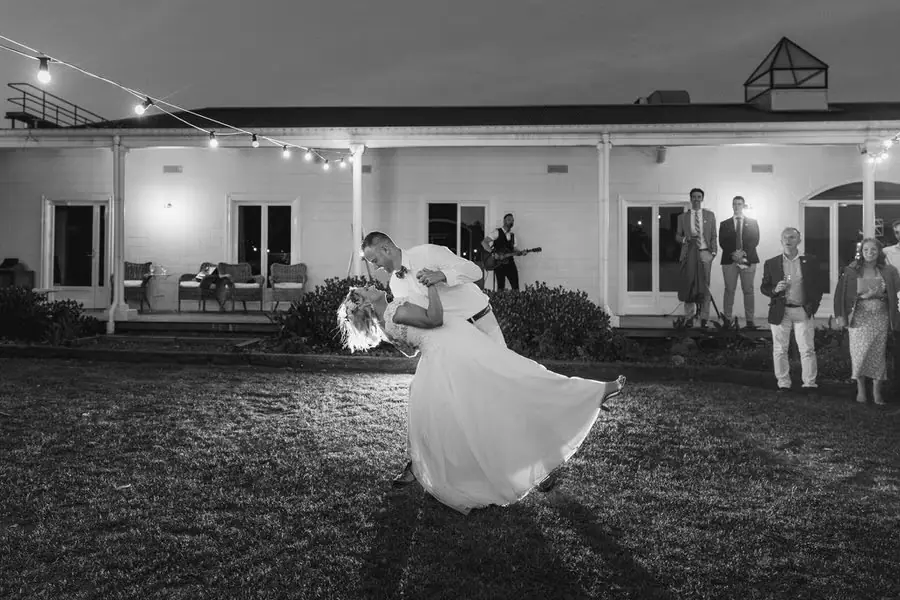 Black-and-white photograph of the groom lifting the bride during their outdoor dance