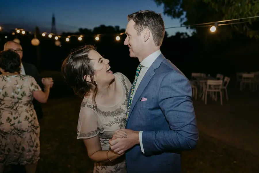 Two guests dancing together and smiling toward one another