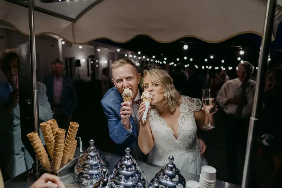 Bride and groom eating ice-cream cones together at a gelato cart