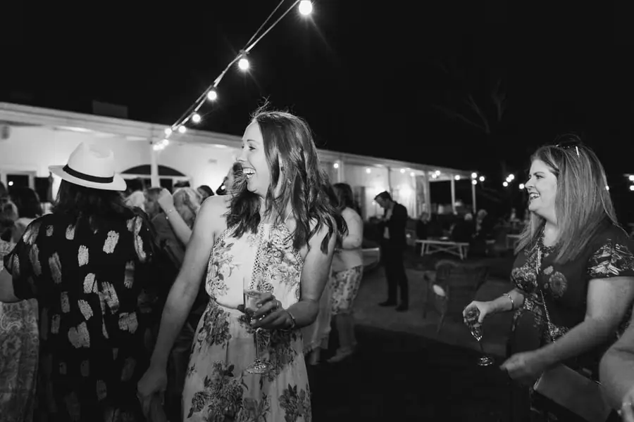 Black-and-white photograph of two women laughing on the outdoor dance floor
