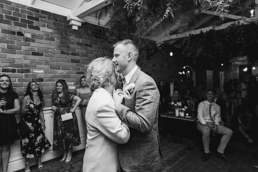 Black-and-white photograph of the bride dancing closely with an older man in a suit