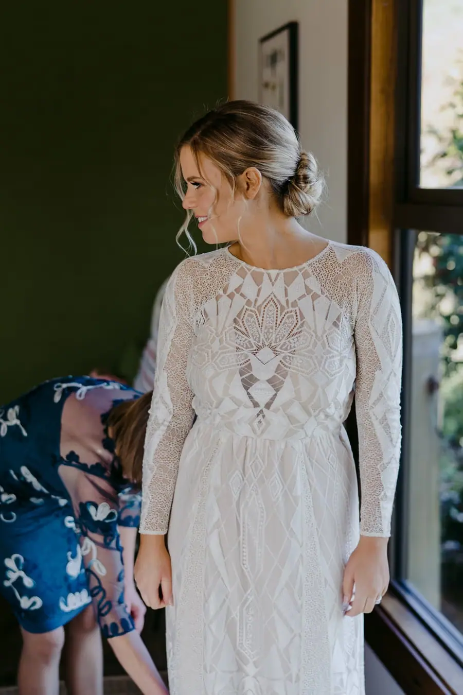 Bride looking to one side while wearing her long-sleeved lace wedding dress
