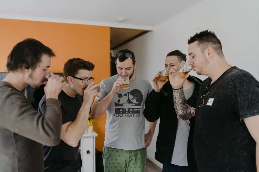 Five men sharing small drinks together in casual clothes