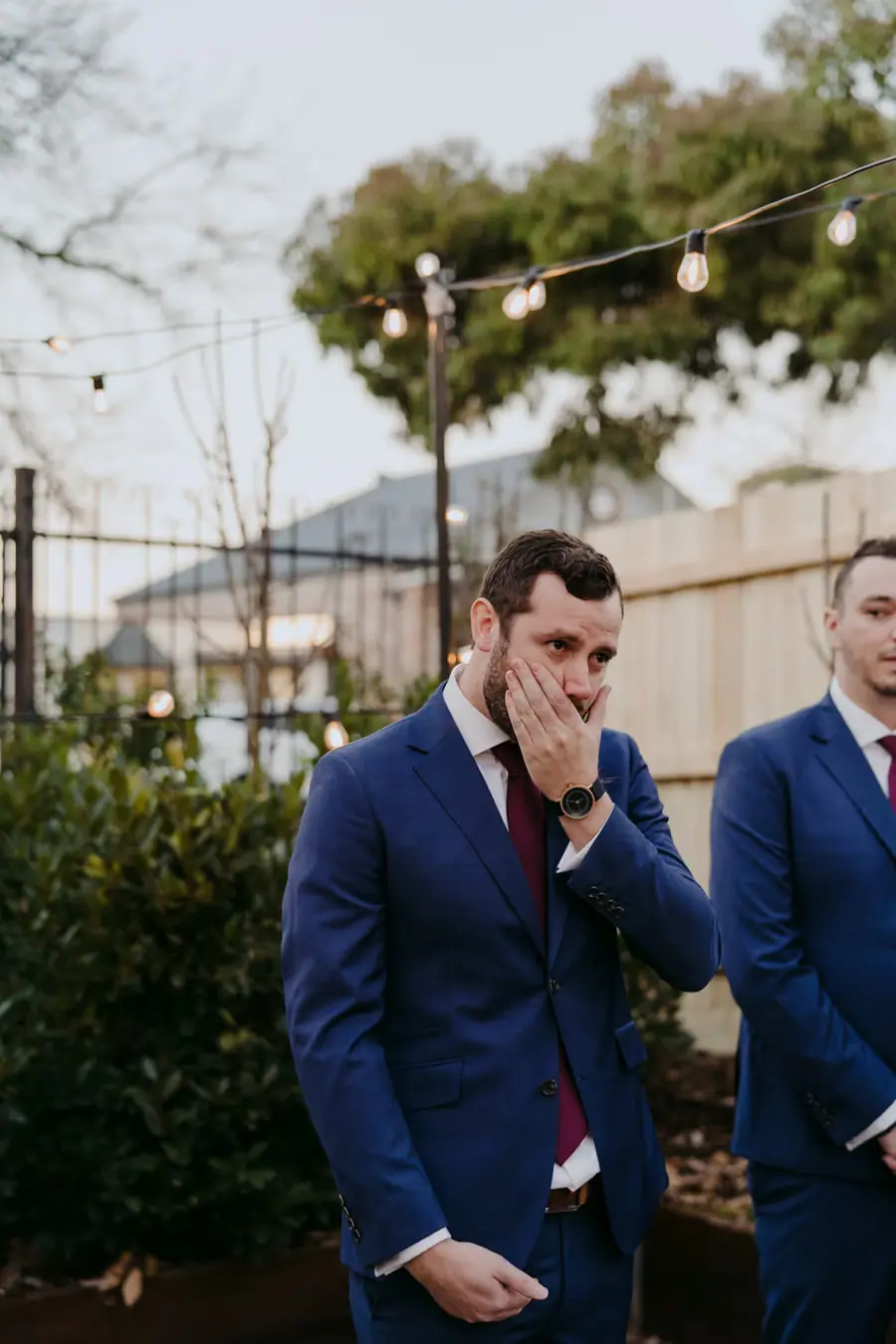 Groom covering his mouth as he watches the approaching bride