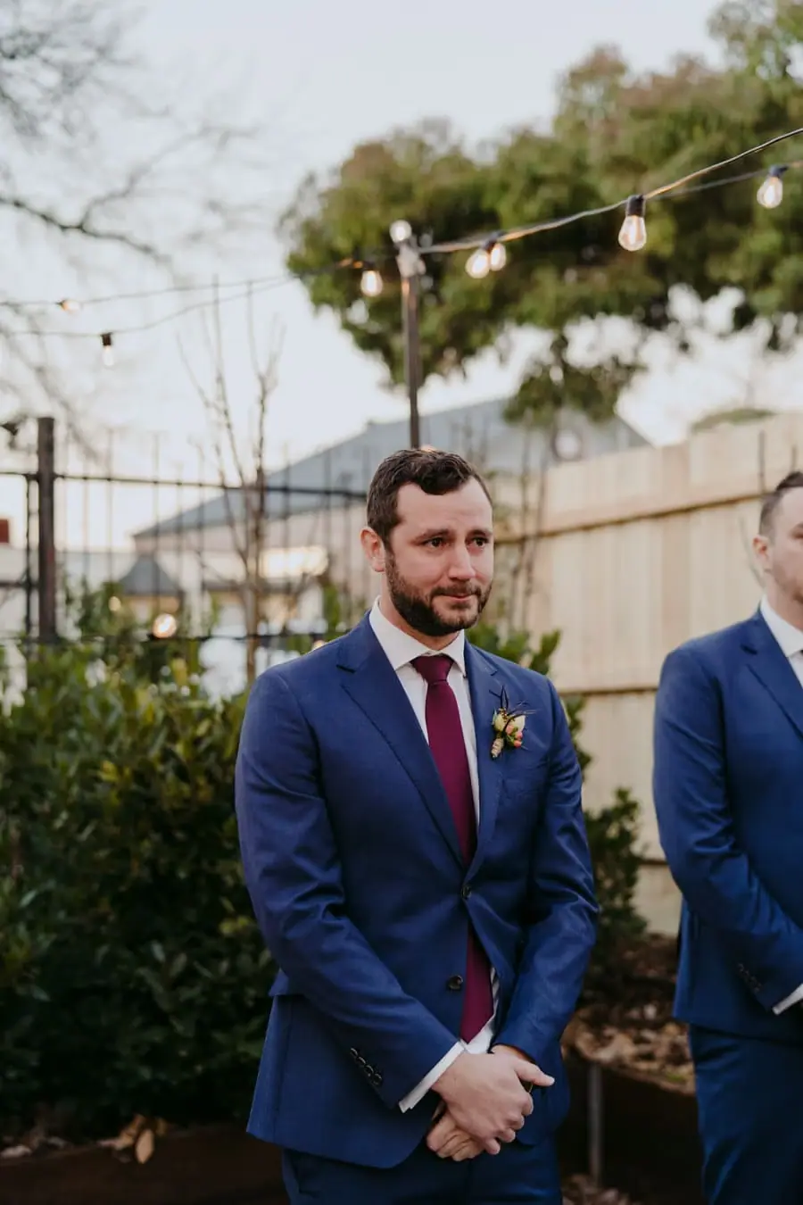 Groom watching the bride with his hands clasped at the ceremony
