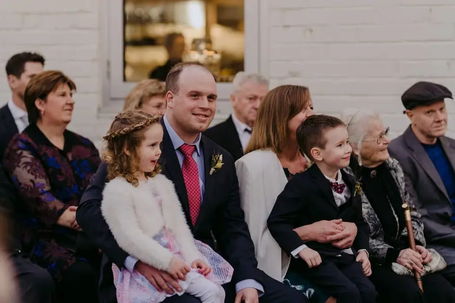 Guests seated with two children in the front row of the ceremony