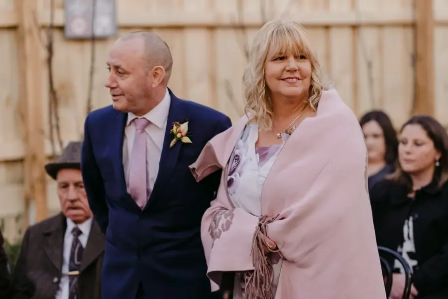Two guests smiling closely together during the courtyard ceremony