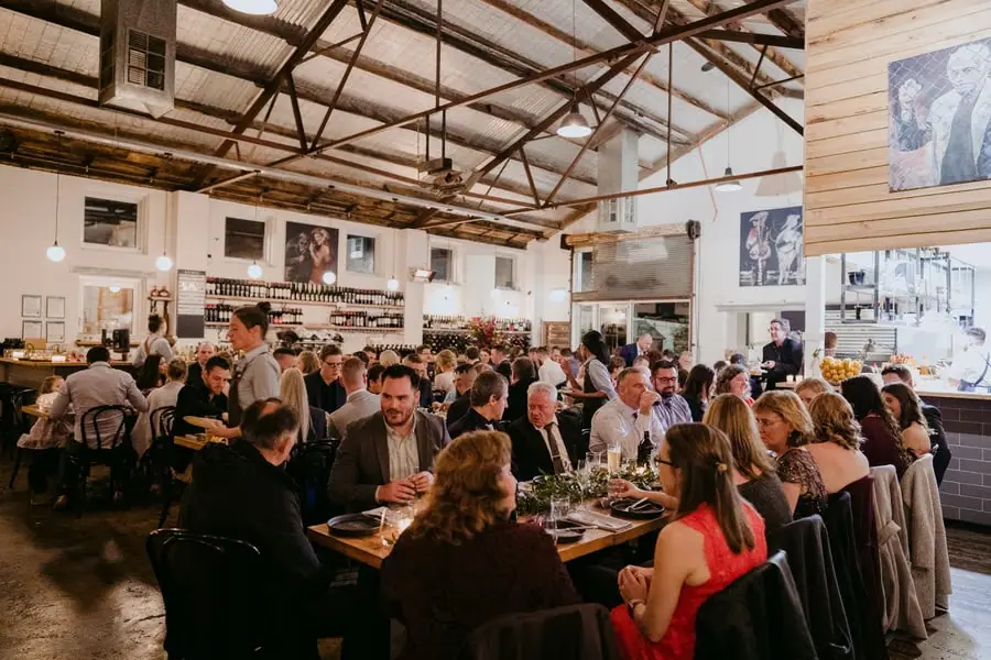Wide view of guests gathered around reception tables inside the restaurant