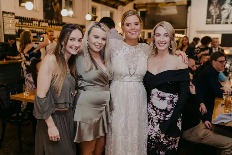 Bride smiling with three guests at the reception