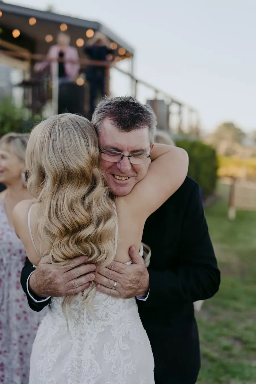 Bride embracing a smiling guest outside the wedding venue