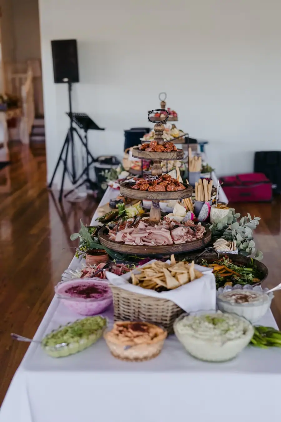 Tiered platters of fruit and savoury food along a reception table