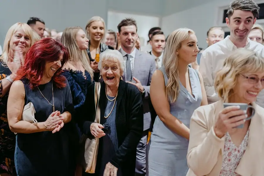 Guests holding hands and laughing together at the reception