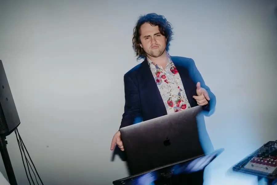 Musician standing behind a laptop and sound equipment