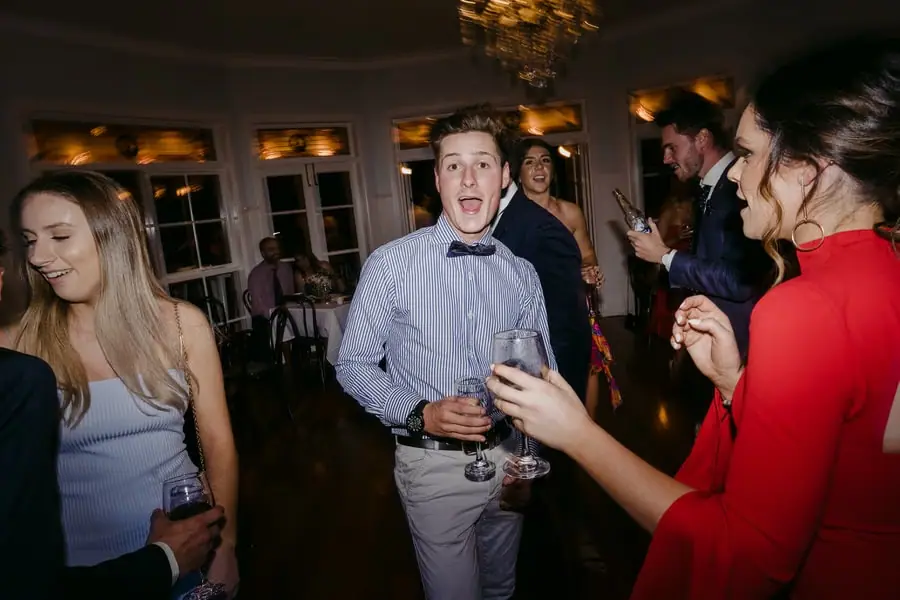 Guests dancing together while holding drinks
