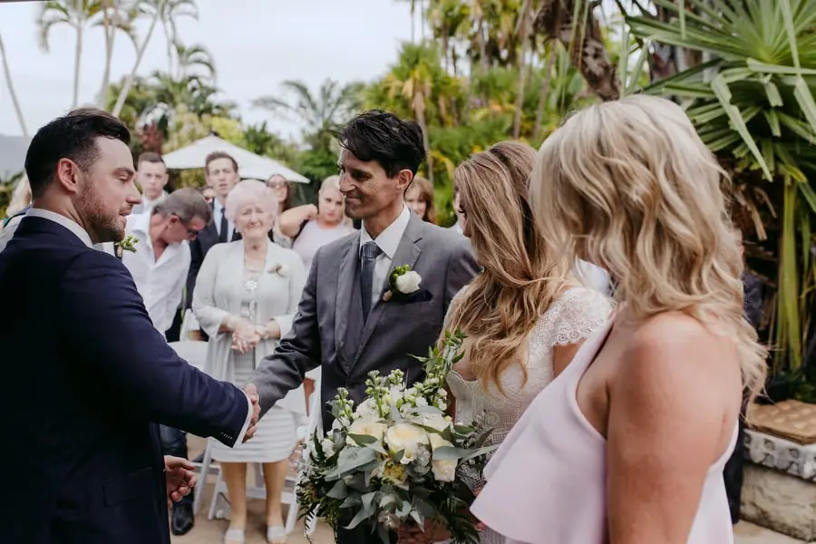 Groom extending his hand toward the bride as she arrives at the ceremony