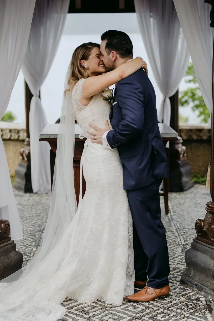 Bride and groom kissing beneath the ceremony pavilion