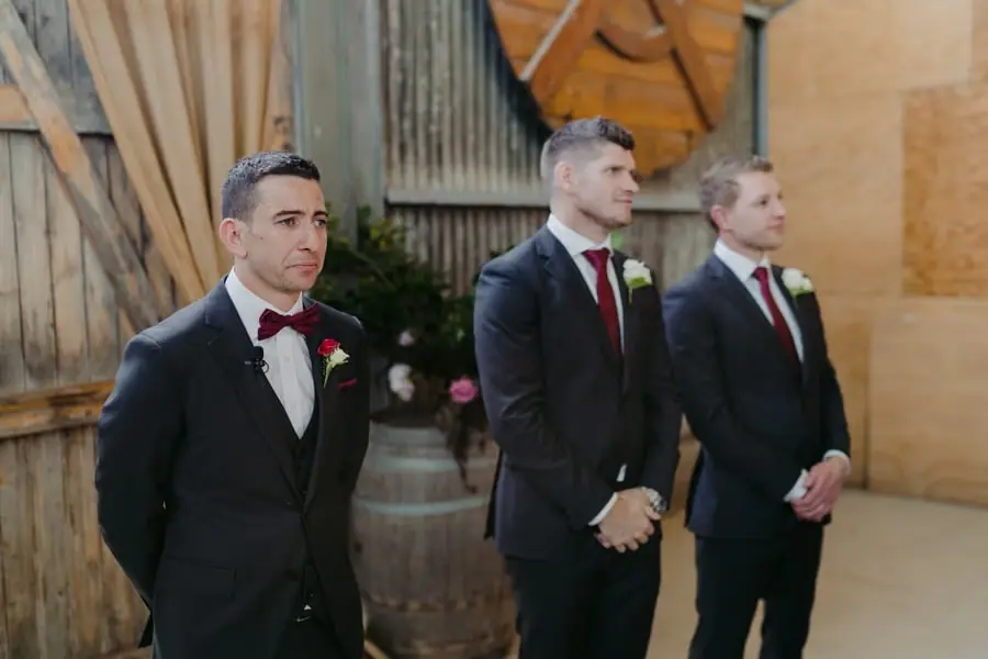 Groom and two groomsmen waiting inside a corrugated metal building