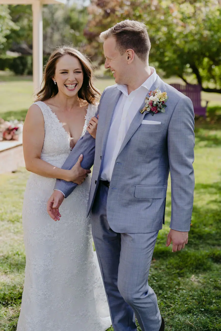 Bride and groom smiling together while standing on the verandah