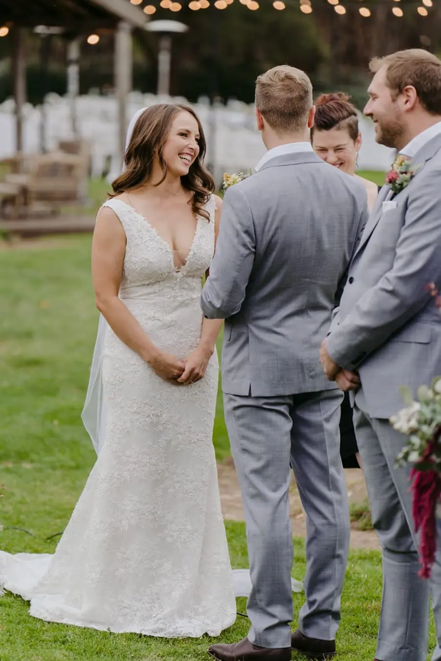 Bride and groom holding hands while smiling at one another