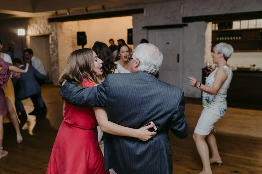 Older man embracing a woman while they dance indoors
